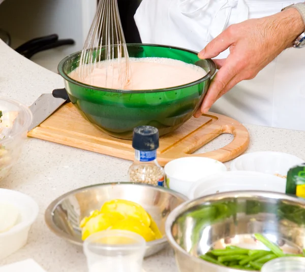 Профессиональные руки шеф-повара с кухонной утварью венчик и сковородка — стоковое фото