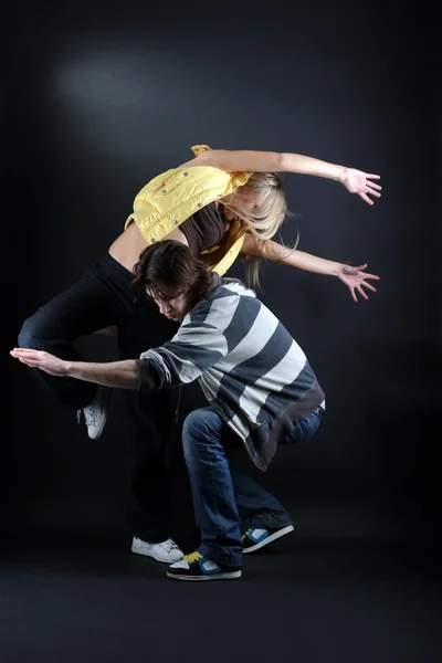 Dançarinos modernos em ação contra o preto — Fotografia de Stock
