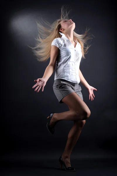 Mladá žena moderní tanečnice v akci proti černé — Stock fotografie