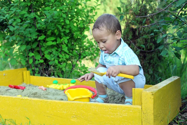 Bebé juega con juguetes en caja de arena —  Fotos de Stock