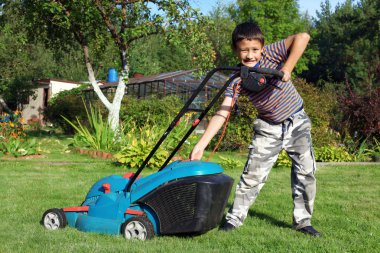 Little Boy Gardener mowing the lawn clipart