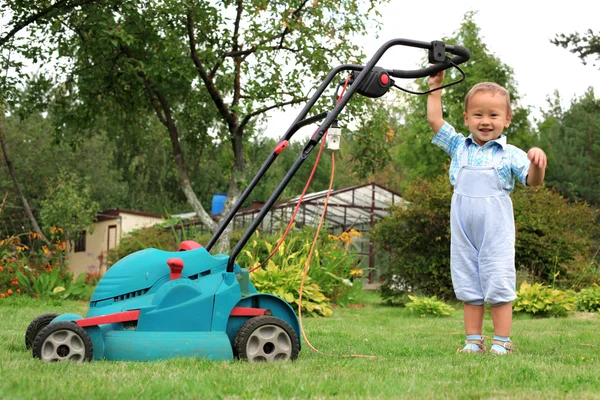 Kleine jongen tuinman maaien van het gazon — Stockfoto