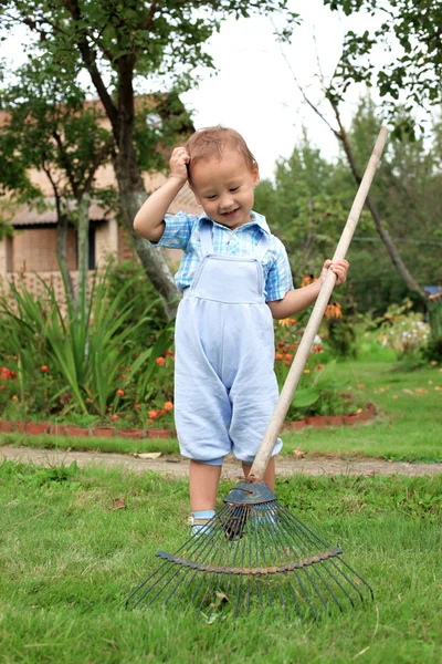 Kleine jongen met rake — Stockfoto