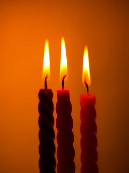 Três velas no amarelo — Fotografia de Stock