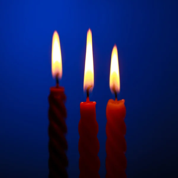Três velas no azul — Fotografia de Stock