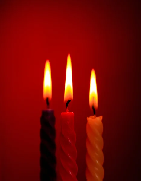 Drie kaarsen op rood — Stockfoto