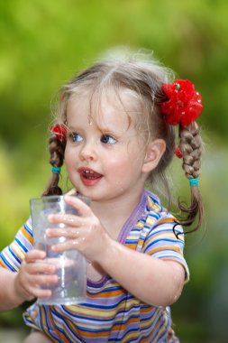 Child drinking glass of water. clipart