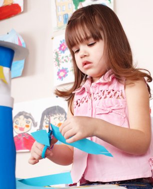 Serious child cutting paper. clipart