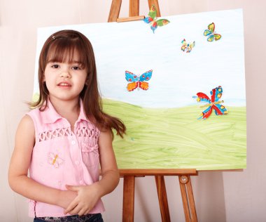 Child with easel in preschool. clipart