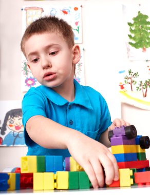 Child playing lego block and construction set. clipart