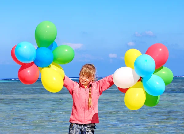 Kind spielt mit Luftballons am Strand — Stockfoto