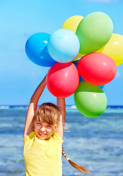 Bambino che gioca con i palloncini in spiaggia — Foto Stock