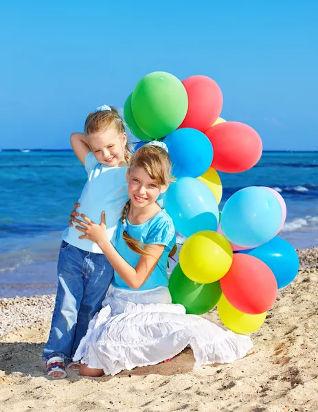 Дети играют с воздушными шарами на пляже — стоковое фото