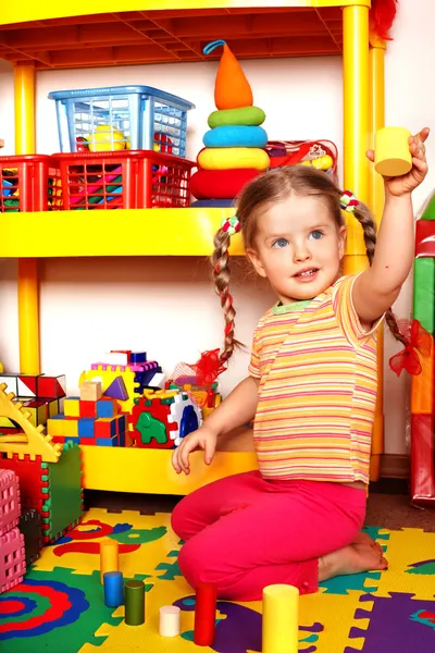 Criança com quebra-cabeça e bloco de madeira na sala de jogos . — Fotografia de Stock