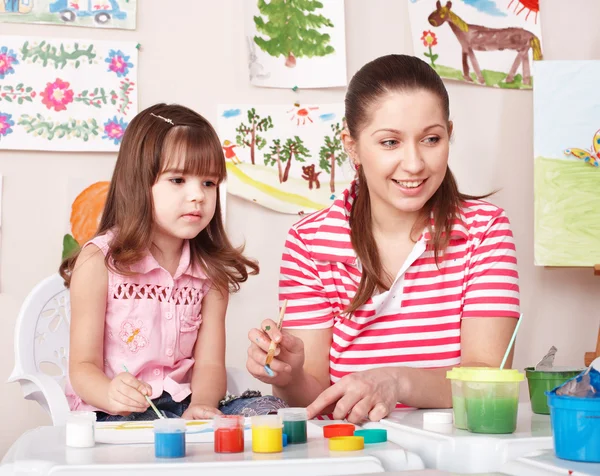 Παιδί με χρώματα κλήρωση δάσκαλος στην αίθουσα παιχνιδιών. — Φωτογραφία Αρχείου