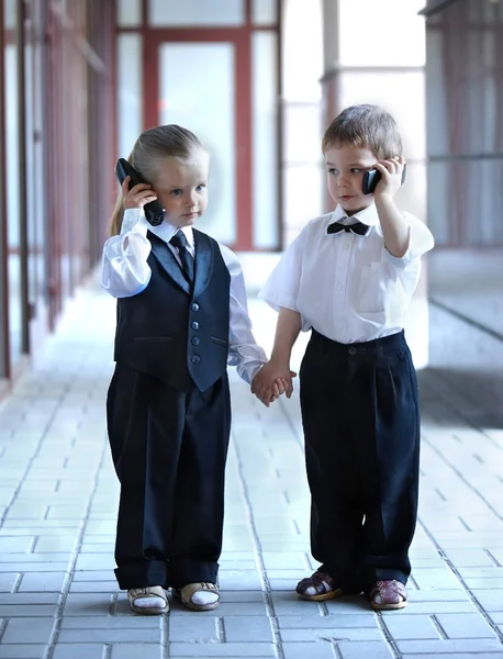 Children in business suit with mobile phone outdoors. — Stock Photo, Image