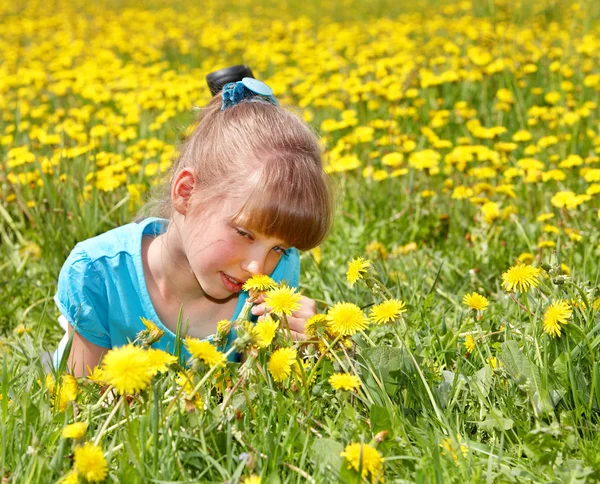 Dziewczynka leżąc na trawie w kwiat. — Zdjęcie stockowe