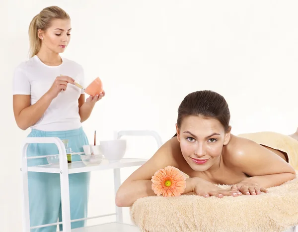 Mujer joven en mesa de masaje en spa de belleza . —  Fotos de Stock