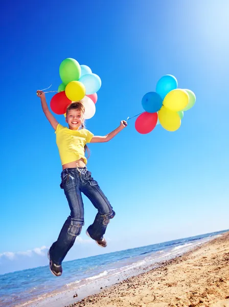 Dítě hraje s balónky na pláži — Stock fotografie