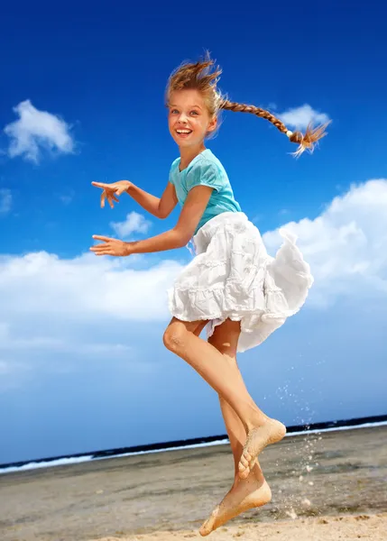 Niño jugando en la playa aganist cielo azul . —  Fotos de Stock