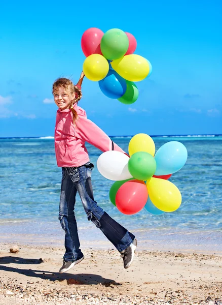 Child playing with balloons at the beach — Stock Photo, Image
