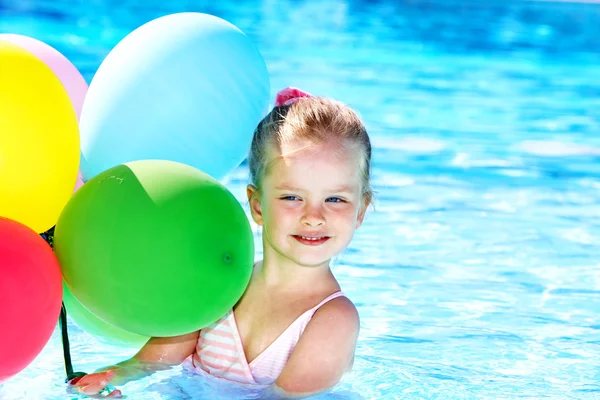Kind spelen met ballonnen in zwembad. — Stockfoto