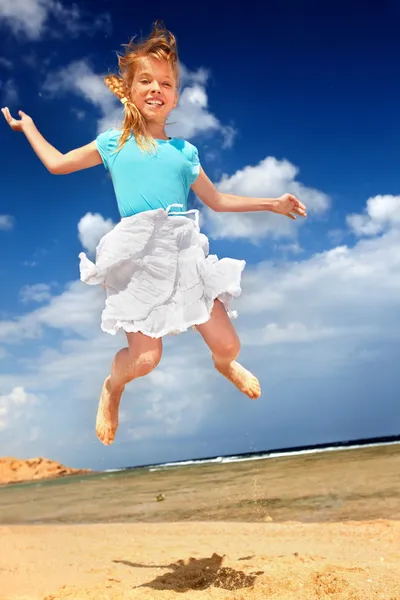 Bambino che gioca sulla spiaggia aganista cielo blu . — Foto Stock