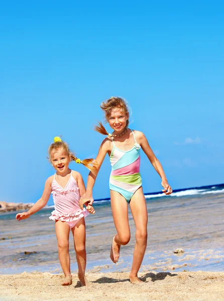 Crianças de mãos dadas a correr na praia . — Fotografia de Stock