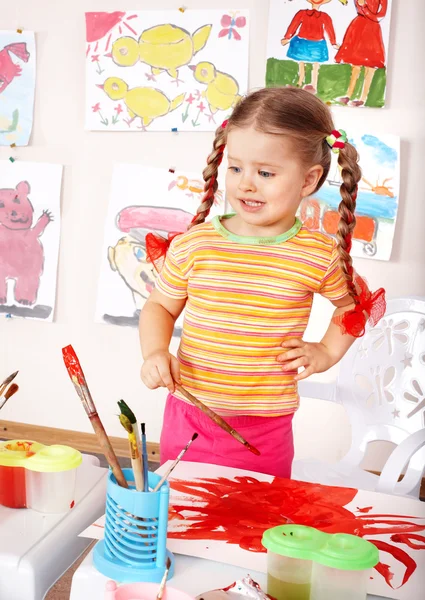 Child with picture and brush in playroom. — Stock Photo, Image