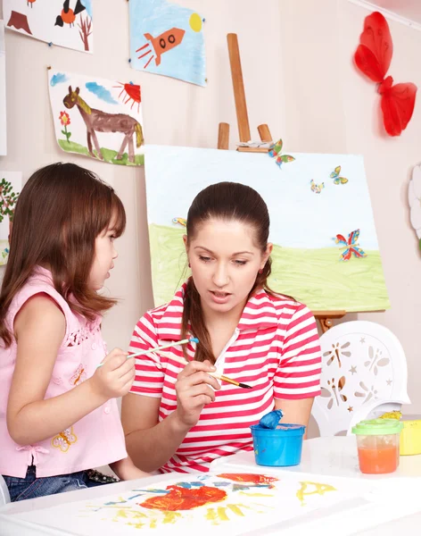 Barn målar med lärare i förskolan. — Stockfoto
