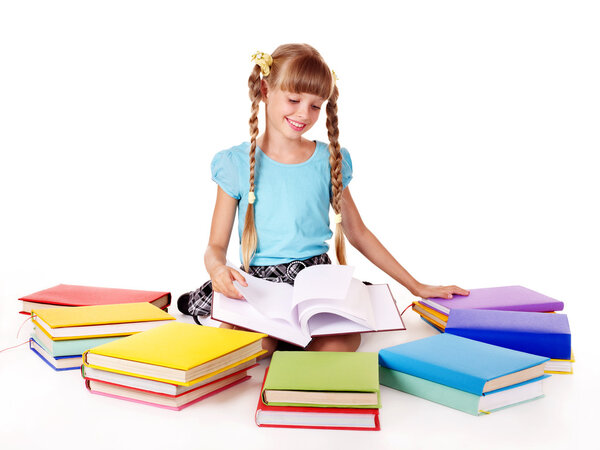 Child with pile of books reading on floor.