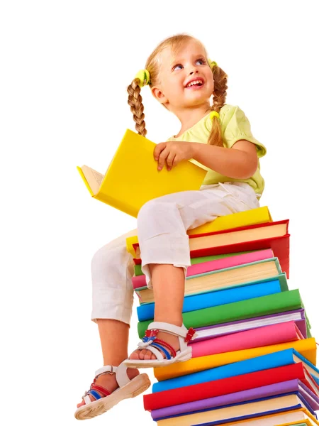 Dítě sedí na stoh knih. — Stock fotografie