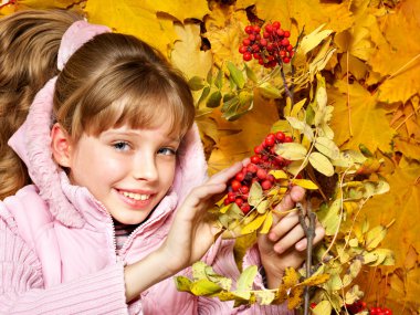 Kid in autumn orange leaves.