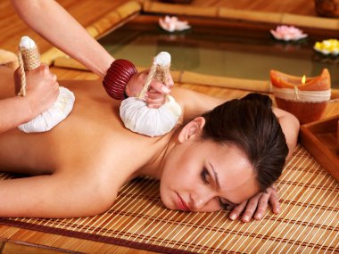 Woman getting massage in bamboo spa. clipart