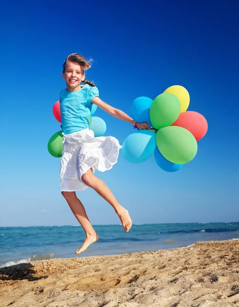 Child playing with balloons at the beach — Stock Photo, Image