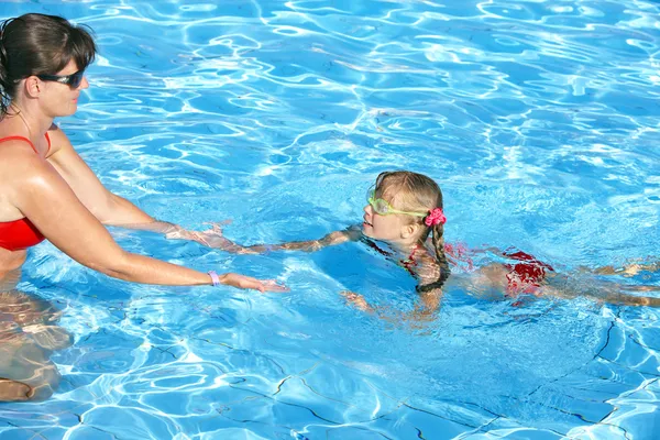 水泳インストラクターの子供の泳ぎを学ぶ. — ストック写真