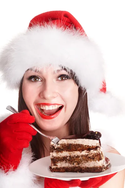 Noel Baba şapkalı kız Noel kek yemek . — Stok fotoğraf