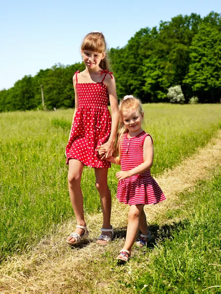 Crianças caminhando através de grama verde ao ar livre . — Fotografia de Stock