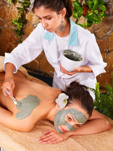 Stock image Young woman having clay body mask.