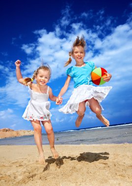çocuklar kumsalda oynarken.