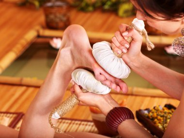 Woman getting foot massage in bamboo spa. clipart