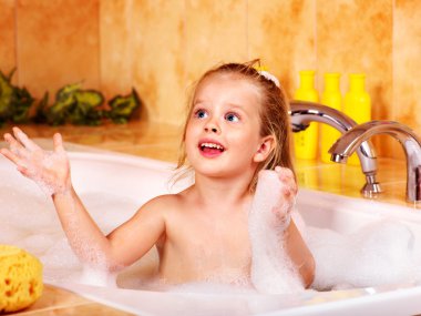 Kid washing in bath. clipart