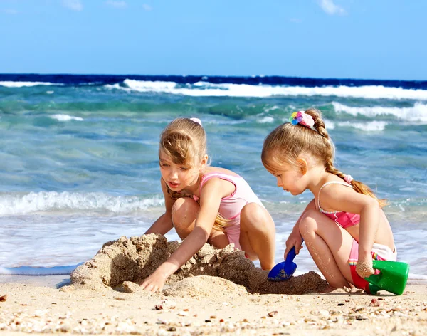 Kinderen spelen op strand. 