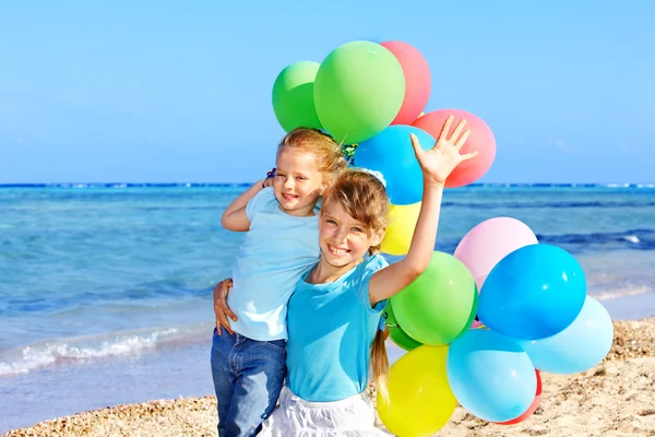 Niños jugando con globos en la playa — Foto de Stock