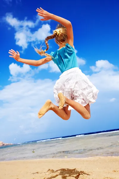 Παιδί που παίζει στην παραλία μπλε ουρανό. — Φωτογραφία Αρχείου