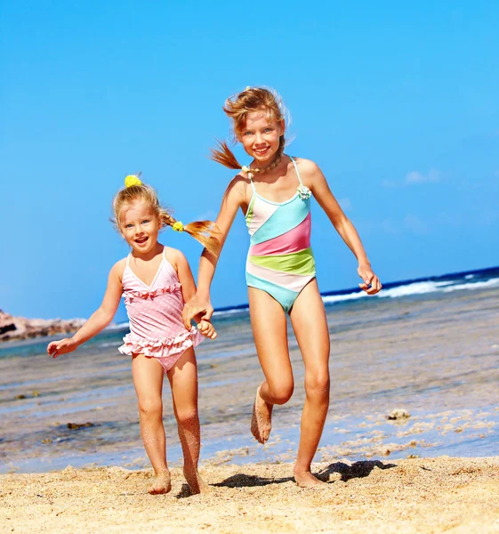 Kinder halten Händchen beim Laufen am Strand. — Stockfoto