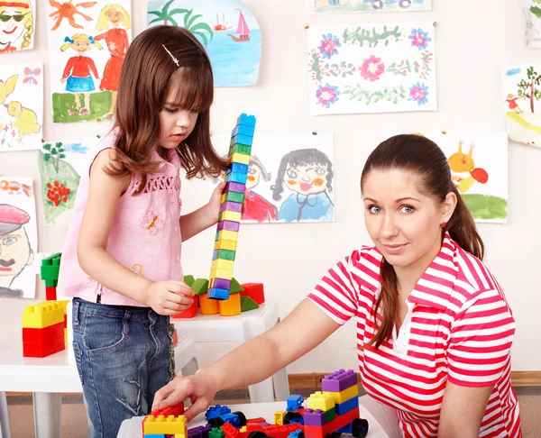 Criança com bloco de madeira e conjunto de construção na sala de jogos . — Fotografia de Stock