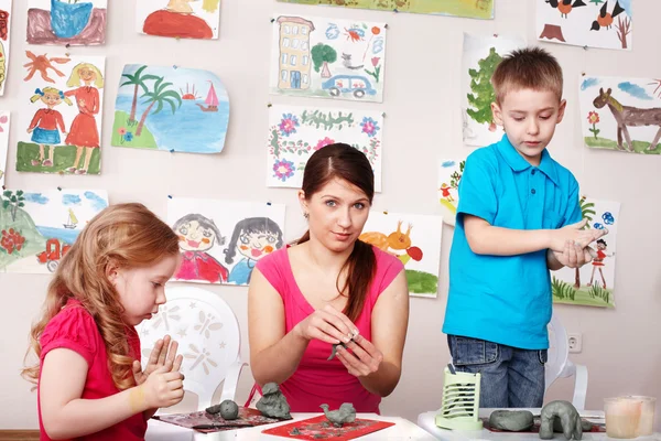 プレイルームで粘土からグループ児童と教師の金型. — ストック写真