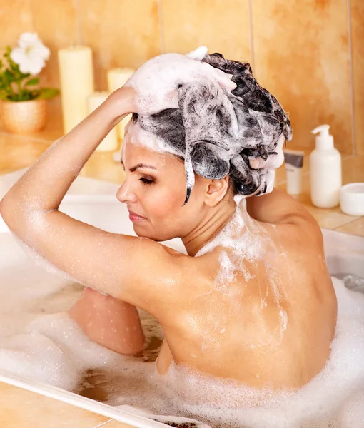 Vrouw wassen haar met shampoo . — Stockfoto
