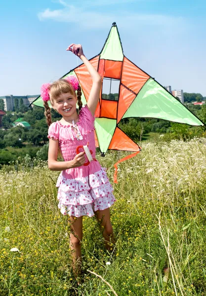 Meisje in groene gras vliegen vlieger. — Stockfoto